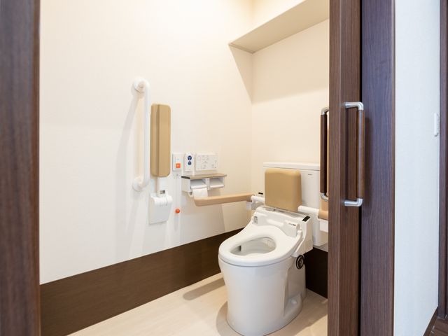バリアフリートイレ設備 トイレ 手すり付き清潔なトイレ空間です。快適な利用を支える配慮が見受けられます。