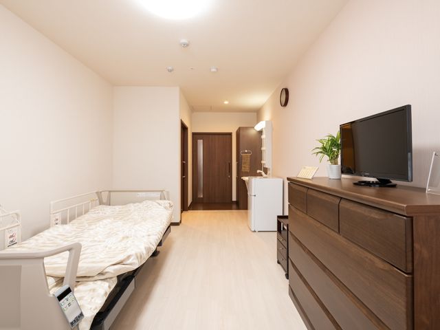 居室の明るい空間 居室 広々とした居室には、必要な備え付け家具が整い、個々のくつろぎの時間をサポートします。安心して日常生活を送れる環境がここにあります。