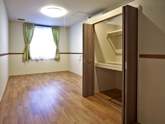 居室の内部空間 居室 ゆったりとした造りの居室です。木目調の収納と床が温もりのある雰囲気を醸し出しています。