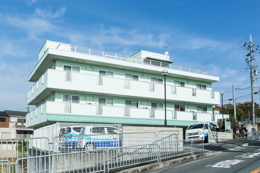 白い外壁の三階建て建物