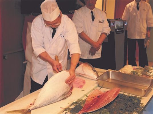 料理人が魚を調理