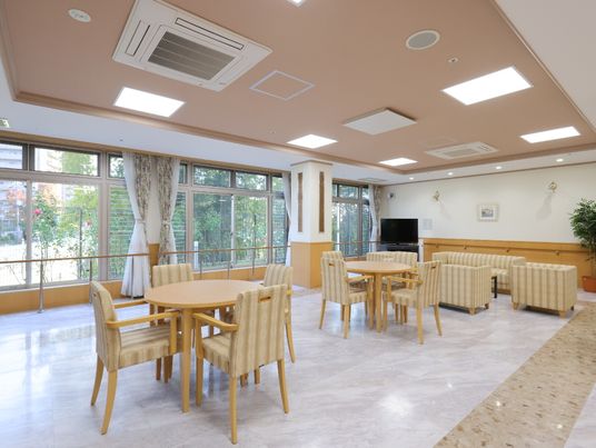 天井にエアコンがあり、テーブルと椅子が4つ置かれている共有スペース
