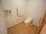 サムネイル 施設の写真 フローリングに白い壁で、清潔感のあるトイレ。引き戸になっていて中が広く、壁には手すりがある。