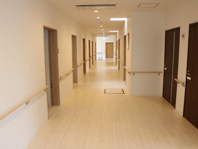 明るい廊下 廊下 手すりが整備された清潔感溢れる廊下です。スタッフの行き来も多く、活気に満ちた雰囲気を感じられます。
