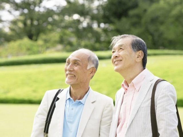 笑顔の二人の高齢者 温かな光の中、二人のご高齢者が柔らかな笑顔で何かを眺めており、穏やかな時間を楽しむ様子が伝わってきます。