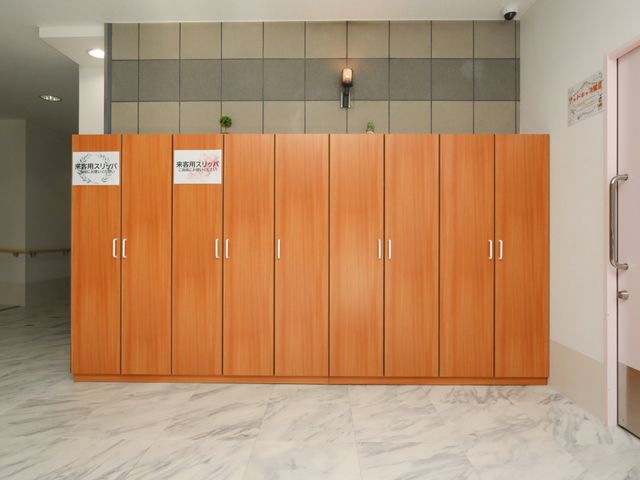 明るいフロント受付 エントランス 清潔で温かみのある木目調のフロントです。ここで日々の連絡や情報交換が行われています。