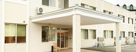 白壁に窓のある建物入口