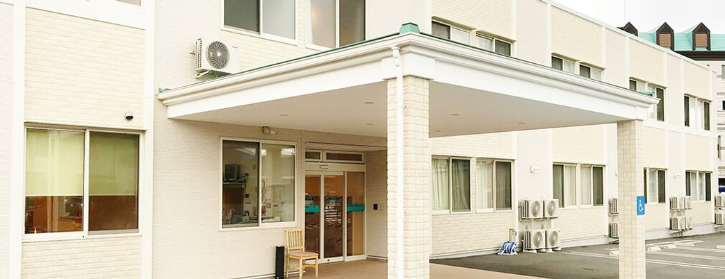 白壁に窓のある建物入口