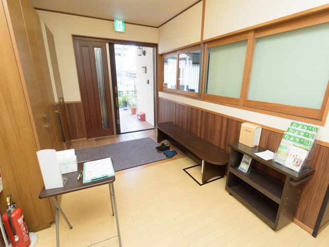 エントランスの明るい空間 玄関内部 清潔で開放的なエントランスです。受付にはパンフレットが置かれ、来訪者を暖かく迎えています。