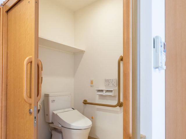 手すり付きの設備トイレ トイレ 広々として使いやすい空間です。手すりが設置され、安全面にも配慮されています。