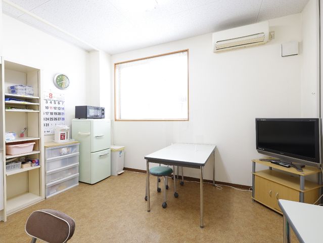 清潔な休憩室 共有スペース こちらはスタッフ用の休憩室で、清掃が行き届いており、リラックスできる配置となっています。電子レンジや冷蔵庫も備えており、快適に過ごせる環境です。