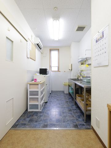 清潔なキッチン全体図 共有スペース キッチンは清潔感あふれる広々とした空間で、スタッフの快適な作業を支えます。日々の業務が円滑に進むよう整理整頓されています。