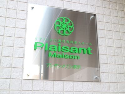 緑のロゴ入り銀色看板