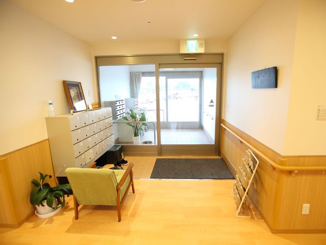 玄関付近の明るい通路 玄関 手すり付きの温もりあるエントランスです。静かな雰囲気の中、書籍や植物が優しい歓迎をしてくれます。