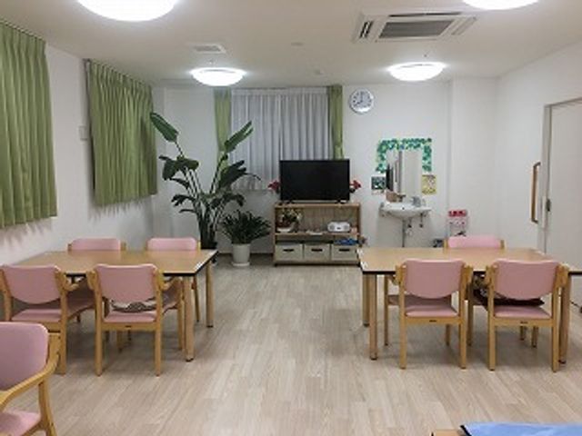 共有スペースの明るい居室 食堂 ゆったりとした空間のラウンジは、テレビや植物が置かれ、心安らぐ共有場所としてご利用いただけます。ここでのお時間は、日々の潤いにつながるでしょう。