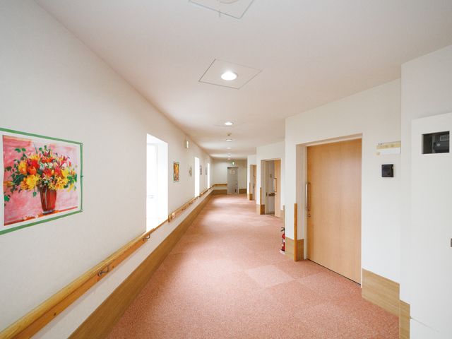 温もり感じる明るい廊下 廊下 手すりが設置されたきれいな廊下は、バリアフリー設計になっており、安全かつ快適な移動を支援します。