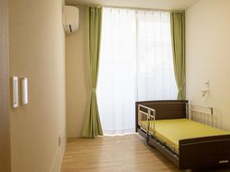 明るい居室のベッドと窓