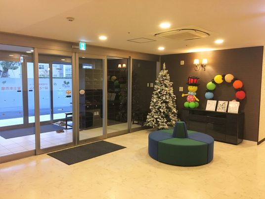 クリスマスの飾りつけが置かれている施設のエントランス。シックな色合いの壁と丸型のソファが印象的なスペース