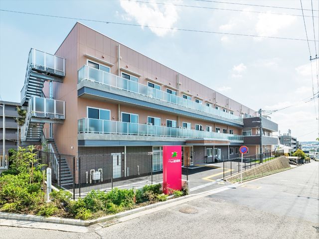 ピンク色の外壁の建物 外観 日当たりの良い清潔感ある建物の正面です。入りやすい環境が整っており、新たな職場として魅力的です。