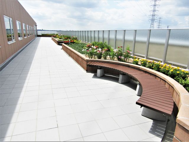 屋上にある憩いの空間 屋外庭園 心地よい屋上テラスがあり、潤いをもたらす多彩な植物に囲まれています。ゆったりとした木製のベンチで心を和ませるひとときを提供します。