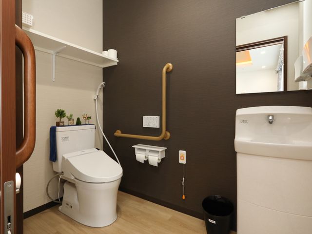 バリアフリートイレ トイレ 洗練されたデザインのトイレは安全性を考えた手すりがあり、快適にお使いいただけます。やさしい色合いで落ち着いた空間を提供しています。