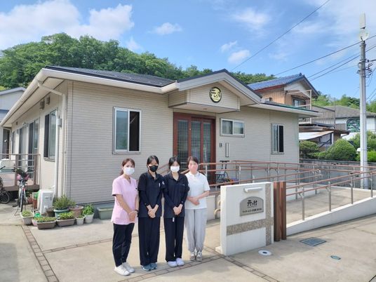スタッフが並ぶ施設外観  