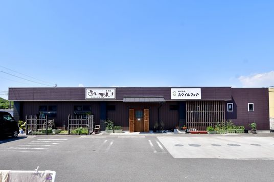 広い駐車場を持つ外観