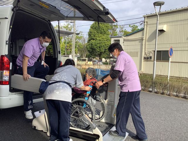 車椅子のサポート場面 エントランス 車椅子利用者をサポートするスタッフの姿が見られます。チームワークを見ることができます。