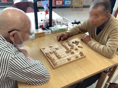 テーブルで将棋を指す人々