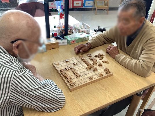テーブルで将棋を指す人々