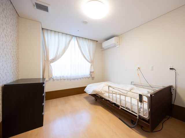 ベッドのある居室 居室 大きな窓から自然光が差し込み、明るい雰囲気の居室です。介護ベッドが設置されていますので、安心してご利用いただけます。