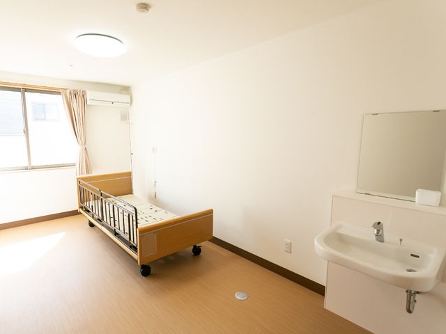 シンプルな居室 居室 すっきりとした設計の個室で、必要な設備が整っており、日々の生活に落ち着きを提供します。明るい窓からは自然光が差し込みます。