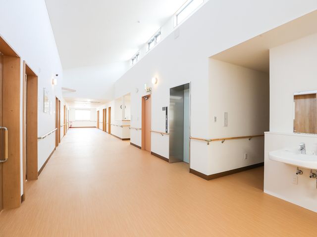 清潔で広々した廊下 廊下 手すり付きで安全性を考慮した明るい通路です。床は滑りにくい材質で、安心して歩行できる環境が整っています。