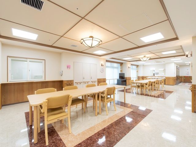 明るい食堂スペース 共有スペース 広々とした食堂は天井が高く、柔らかな照明が心地良い雰囲気を演出しています。共有スペースで笑顔があふれる光景も想像できる、温かみのあるデザインです。