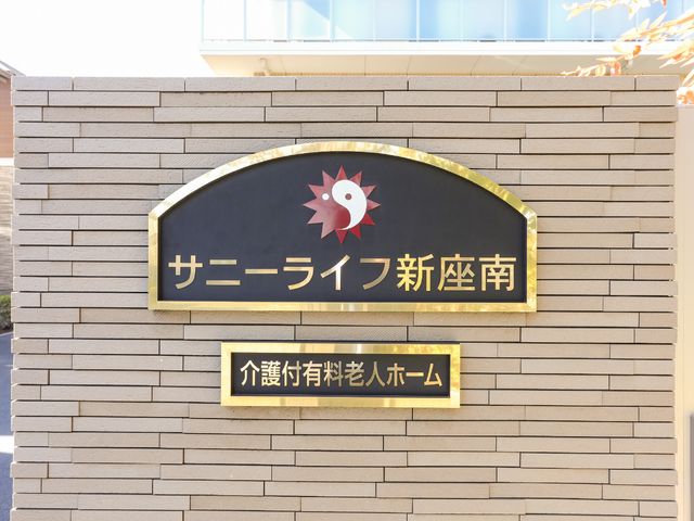 新築感漂う施設の看板 ロゴ モダンなデザインの施設入口を示す看板が設置されており、明るく洗練された印象を受けます。
