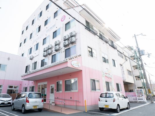 ピンクの外壁の建物エントランス