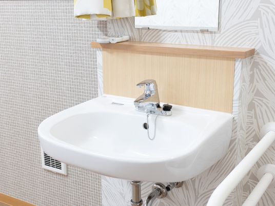 白い洗面台と手すり付き