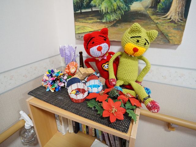 手編みのぬいぐるみと花飾り 展示物 和やかな雰囲気の居室コーナーです。手作りのぬいぐるみが、温もりある生活空間を演出しています。