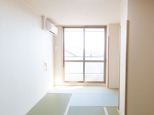 畳が敷かれた居室があり、突き当たりにはバルコニーに出られる窓が付いている。窓の近くにはエアコンを設置。