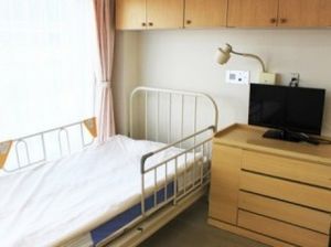 明るい居室のベッドと家具  