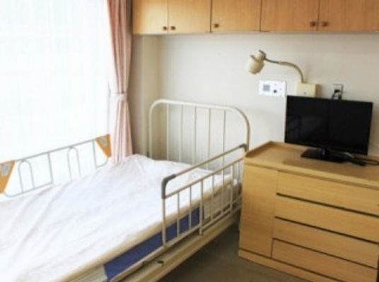 明るい居室のベッドと家具  