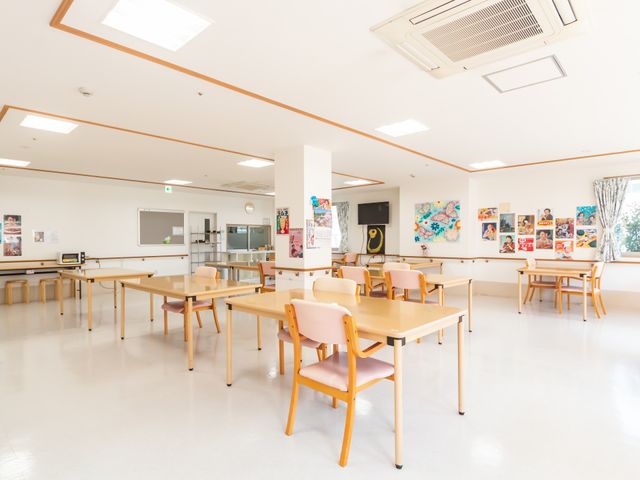 広々としたダイニングルーム ダイニングルーム 広々とした明るいダイニングルームで、壁にはカラフルなポスターが飾られています。机と椅子が整然と配置されています。
