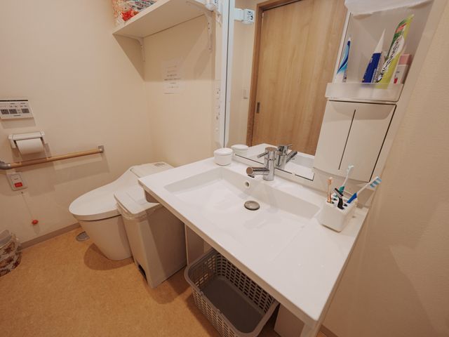 洗面台とトイレの空間 洗面台 清潔感ある洗面スペース。手すりが設置されており、安全性にも配慮されています。