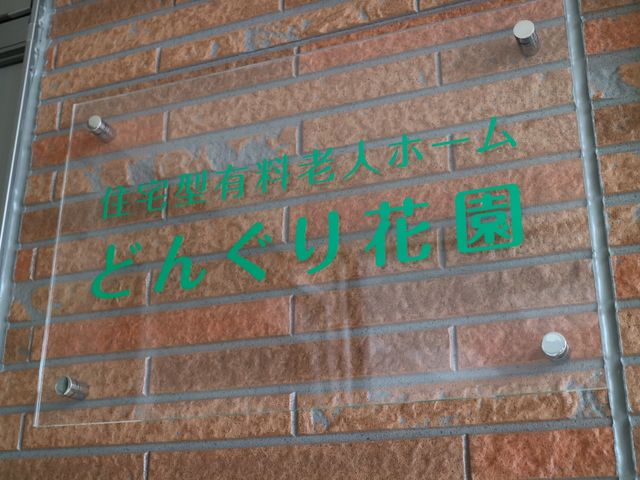 緑色看板の文字 看板 清潔感あふれる壁に取り付けられた、緑色の文字が映える看板。こちらが新たな職場になるかもしれません。