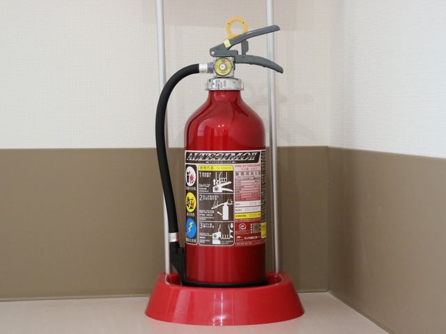 安全設備の消火器 消火設備 廊下に設置された消火器は、いざという時の安全を守る重要な設備です。日々の安心安全な環境づくりに努めています。