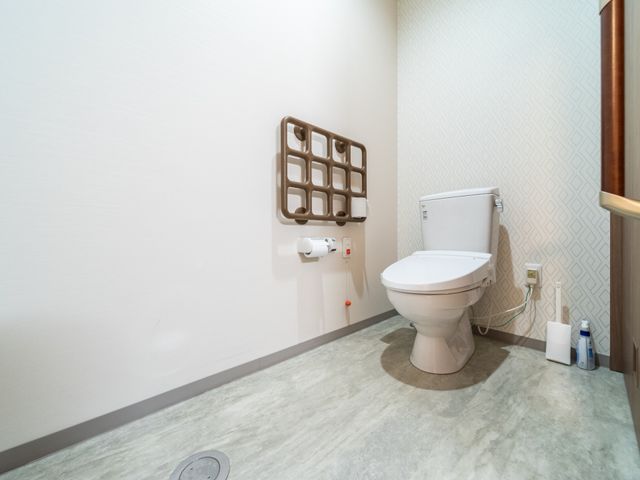 清潔なトイレスペース トイレ 手すり付きのモダンなトイレです。安全に配慮された設計で、どなたでも安心してお使いいただけます。