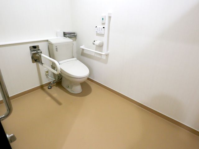 バリアフリーのトイレ施設 トイレ 安全に配慮された設計のトイレです。手すりの付いている壁や広々とした空間は、使い勝手を考えた配慮がされています。