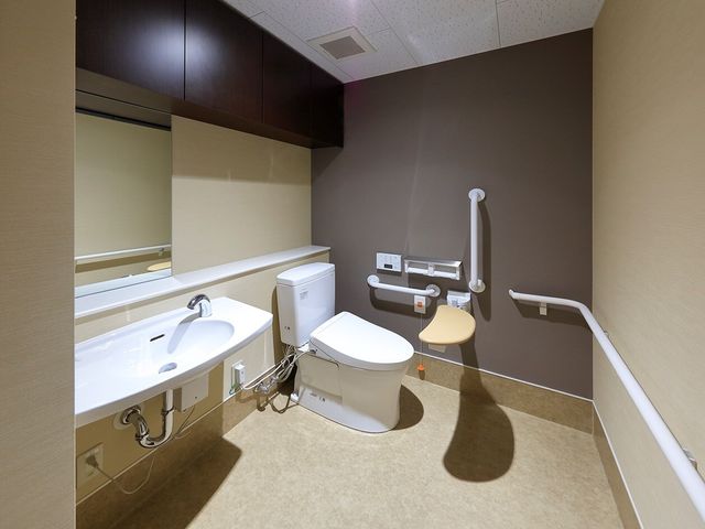 バリアフリートイレの設備 トイレ 手すり付きで安全に配慮されたトイレです。清潔感があり、利用しやすい環境が整っています。
