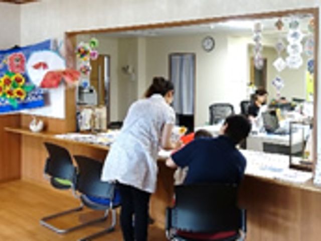 明るい受付の風景 フロント 明るいフロントで、スタッフが来訪者に丁寧に対応しています。温かい雰囲気が魅力的です。