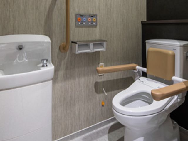 快適なトイレ空間 トイレ 手すり付きの便座で安心して使用できる設備です。落ち着いたデザインで、利用者の方の使いやすさを考慮しています。